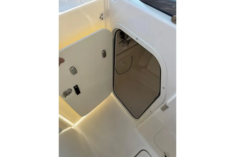 Slide: The Image of Open storage compartment on 2021 Pursuit DC 266 Dual Console boat. - 33