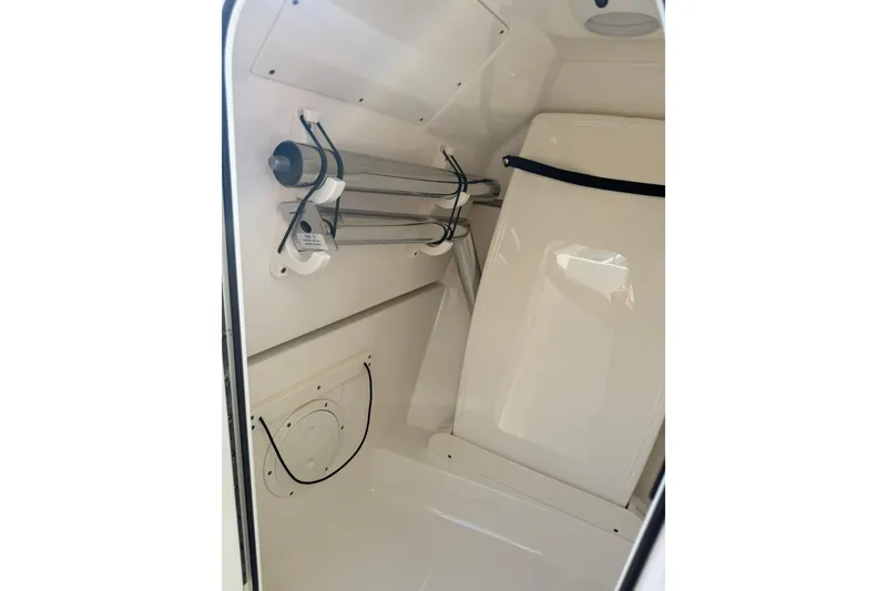 Slide: The Image of Interior of 2021 Pursuit DC 266 Dual Console boat, featuring storage and utility area. - 34