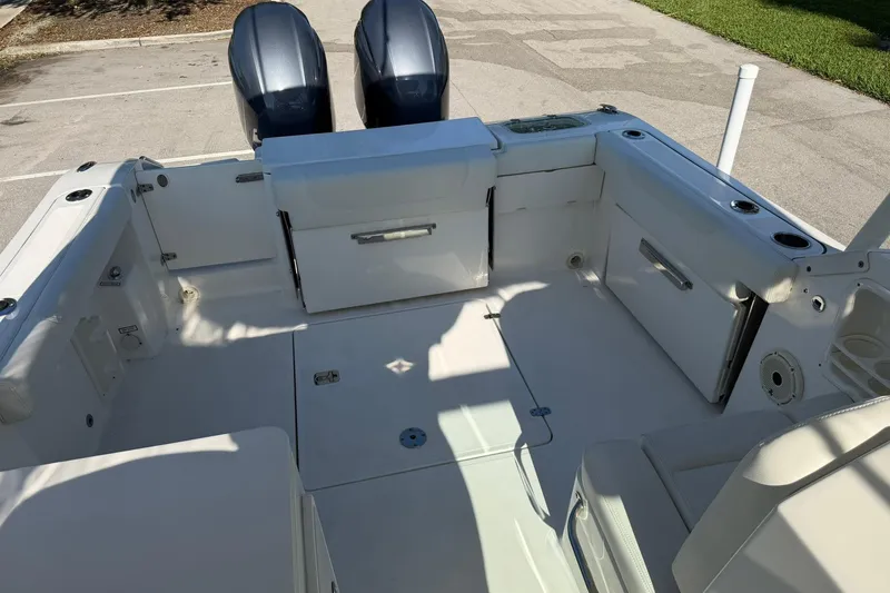 Slide: The Image of 2021 Pursuit DC 266 Dual Console boat interior with twin engines, spacious seating, and storage compartments. - 37
