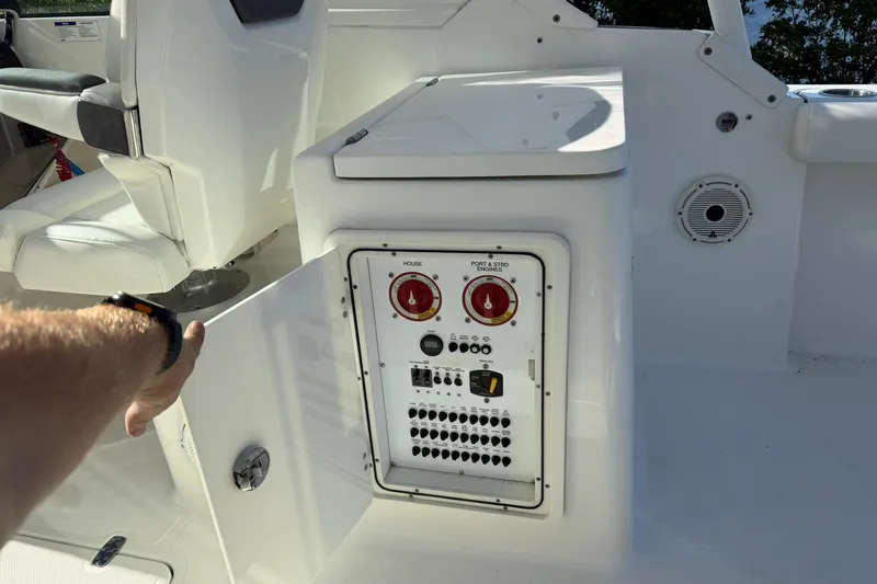 Slide: The Image of Control panel on a 2021 Pursuit DC 266 Dual Console boat, with open storage compartment. - 38