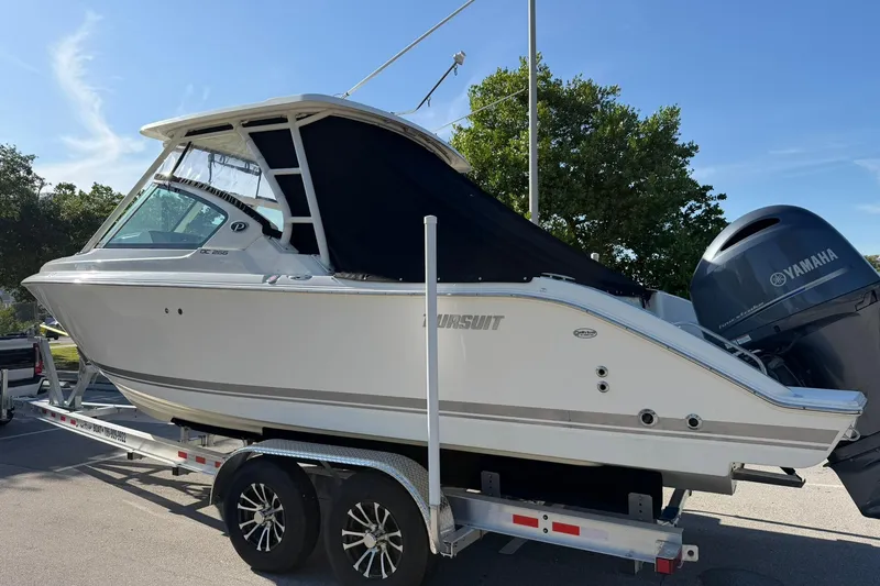 Slide: The Image of 2021 Pursuit DC 266 Dual Console boat on trailer, featuring Yamaha outboard motor. - 39