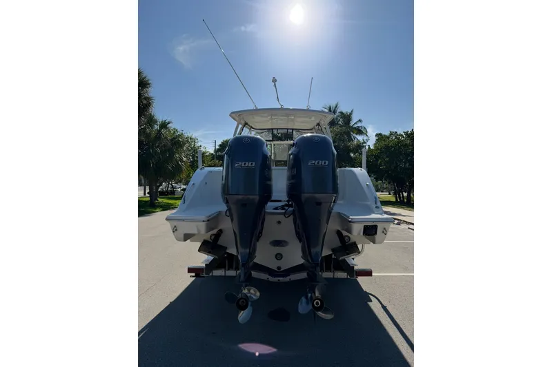 Slide: The Image of 2021 Pursuit DC 266 Dual Console boat with twin 200 horsepower engines, parked outdoors. - 4