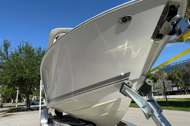 Slide: The Image of 2021 Pursuit DC 266 Dual Console boat on trailer, sunny day, trees in background. - 8