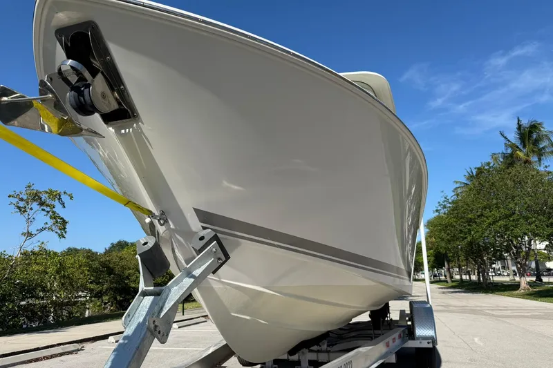 Slide: The Image of 2021 Pursuit DC 266 Dual Console boat on trailer, under clear blue sky. - 9