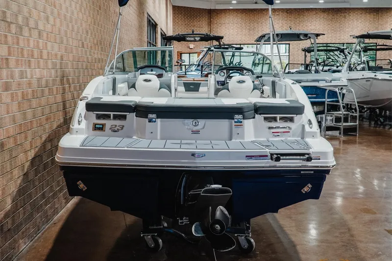 Slide: The Image of 2023 Chaparral 23 SSi boat displayed indoors, showcasing rear seating and sleek design. - 8
