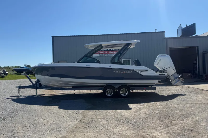 The Image of 2025 Monterey Elite 27 OB boat on trailer, parked outside a building. - 1