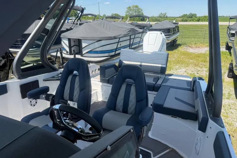 Slide: The Image of 2025 Monterey Elite 27 OB boat interior with plush seating and modern steering wheel. - 14