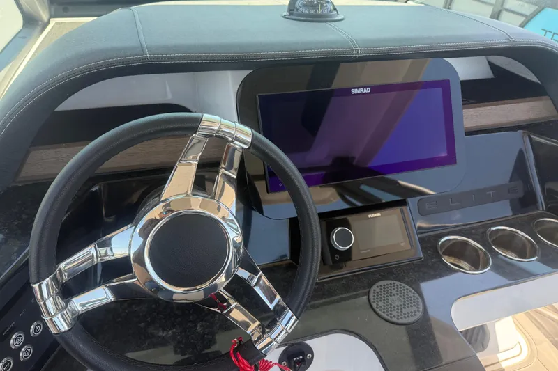 Slide: The Image of Steering wheel and dashboard of 2025 Monterey Elite 27 OB boat with modern controls. - 15
