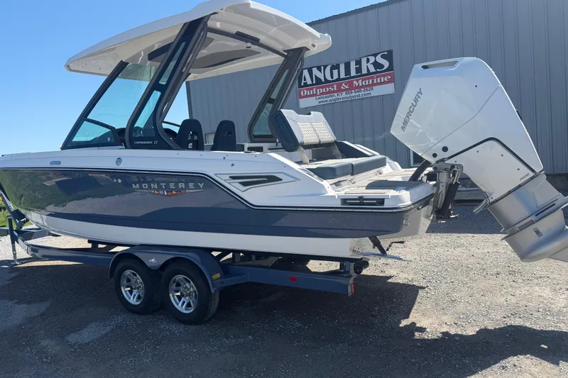 Slide: The Image of 2025 Monterey Elite 27 OB boat on trailer, displayed outdoors at Anglers Outpost & Marine. - 4