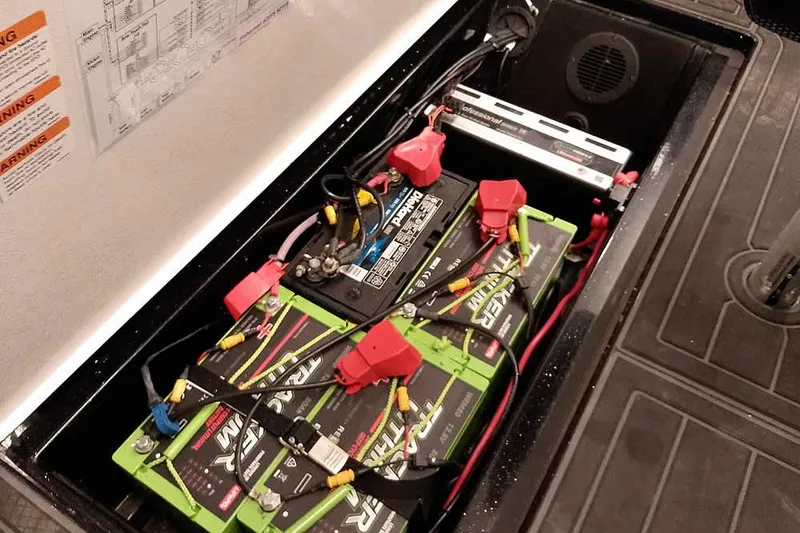 Slide: The Image of 2024 Ranger 621FS Fisherman boat battery compartment with multiple batteries and wiring. - 33
