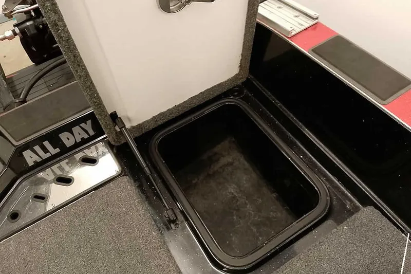 Slide: The Image of 2024 Ranger 621FS Fisherman boat storage compartment with open hatch and carpeted interior. - 38