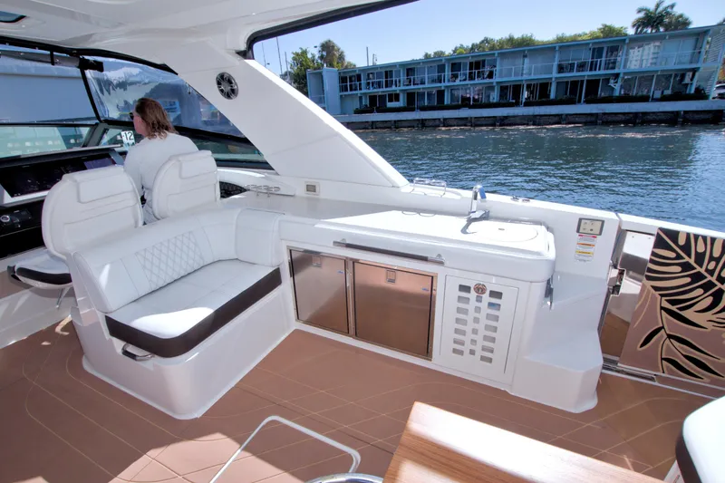 Slide: The Image of 2021 Sea Ray SLX 400 Outboard interior with seating and kitchenette, dockside view. - 23