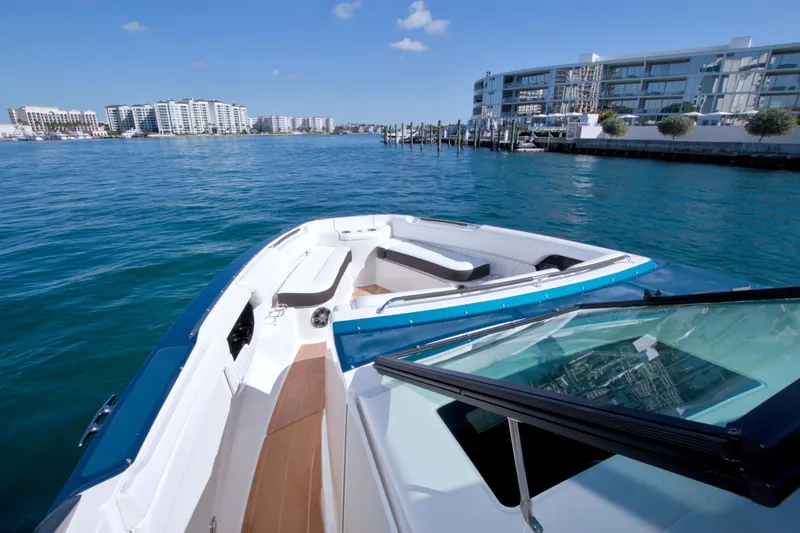 Slide: The Image of 2021 Sea Ray SLX 400 Outboard cruising near modern waterfront buildings. - 32
