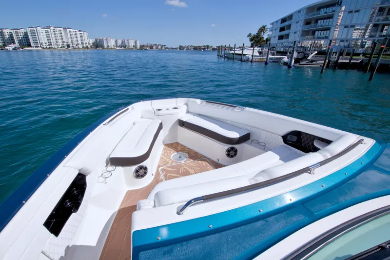 Slide: The Image of 2021 Sea Ray SLX 400 Outboard boat with spacious seating, docked near waterfront buildings. - 33