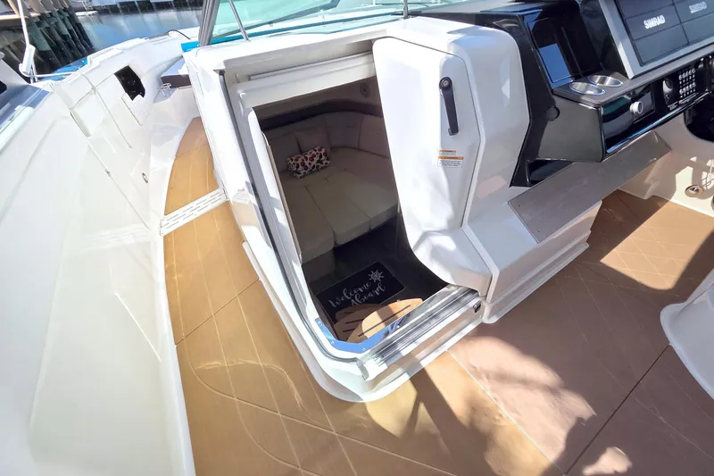 Slide: The Image of 2021 Sea Ray SLX 400 Outboard cabin entrance with seating and helm controls. - 42