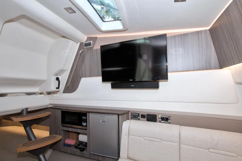 Slide: The Image of Interior of 2021 Sea Ray SLX 400 Outboard with TV, microwave, and seating area. - 46