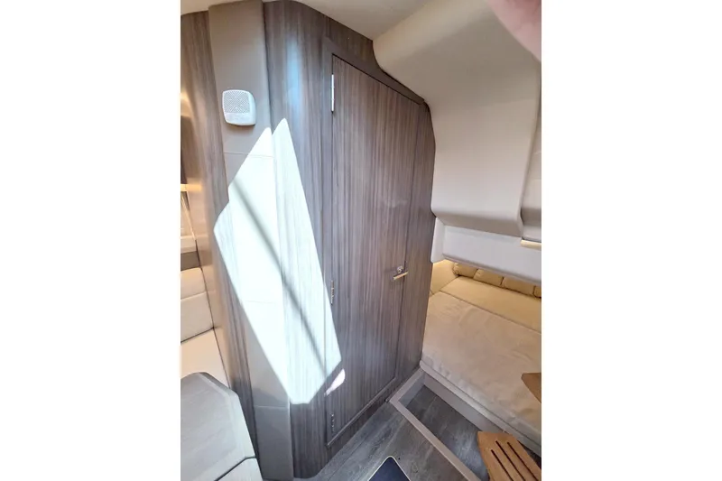 Slide: The Image of 2021 Sea Ray SLX 400 Outboard cabin interior with wood paneling and seating area. - 49