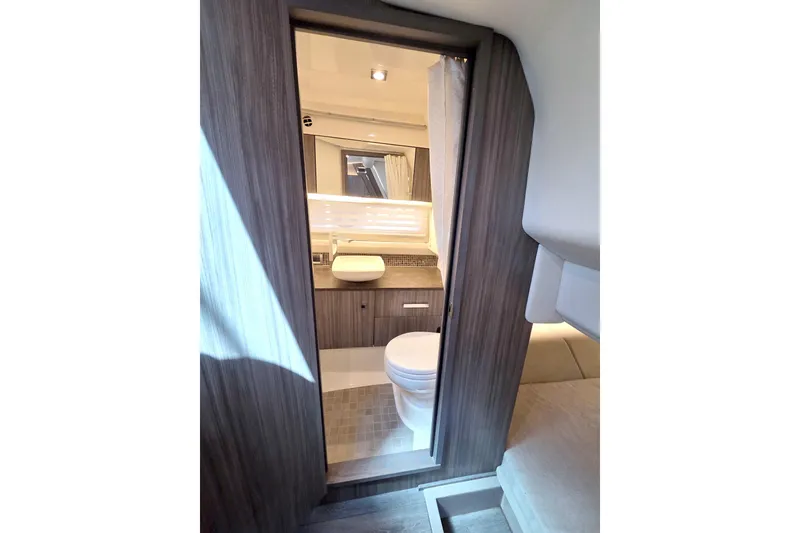 Slide: The Image of Interior of 2021 Sea Ray SLX 400 Outboard bathroom with modern fixtures and wood accents. - 50