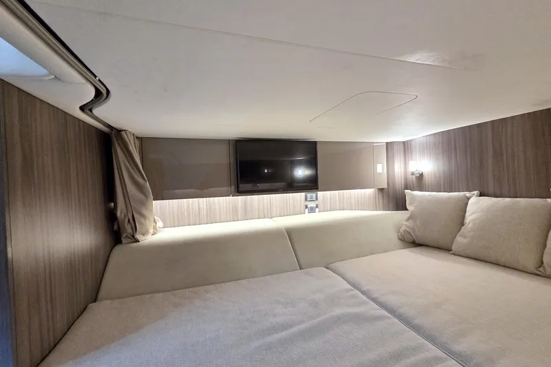 Slide: The Image of Interior cabin of 2021 Sea Ray SLX 400 Outboard with cozy bedding and TV. - 56