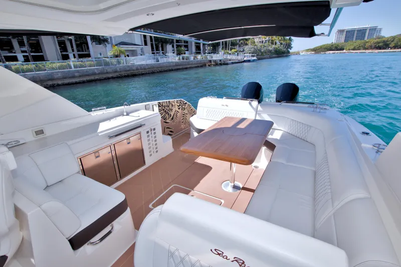 Slide: The Image of 2021 Sea Ray SLX 400 Outboard luxury boat interior with seating and table on water. - 57