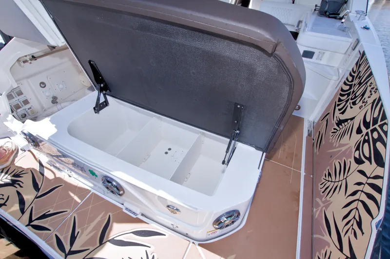 Slide: The Image of Open storage compartment on 2021 Sea Ray SLX 400 Outboard boat with patterned flooring. - 70