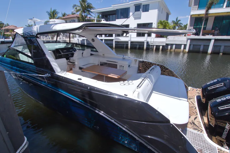 Slide: The Image of 2021 Sea Ray SLX 400 Outboard luxury boat docked by waterfront homes. - 74