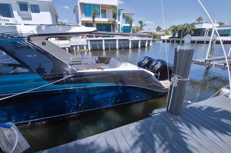 Slide: The Image of 2021 Sea Ray SLX 400 Outboard docked in a sunny marina setting. - 75