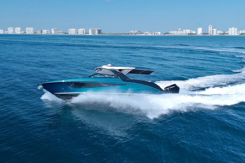 Slide: The Image of 2021 Sea Ray SLX 400 Outboard cruising on open water with city skyline backdrop. - 9
