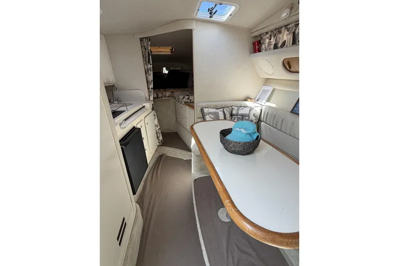 Slide: The Image of Interior of 1997 Sea Ray 290 Sundancer boat, featuring kitchenette and seating area. - 15