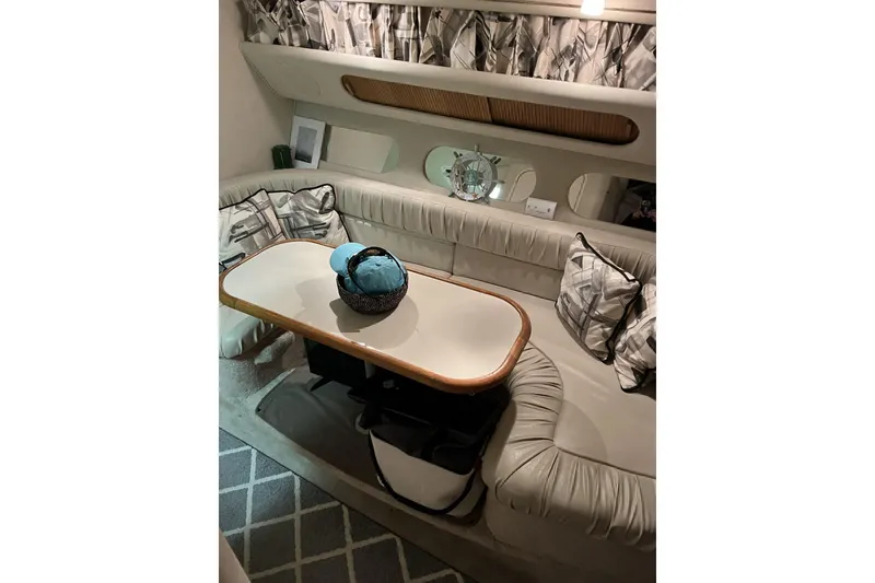 Slide: The Image of Interior of 1997 Sea Ray 290 Sundancer with cozy seating and decorative pillows. - 17