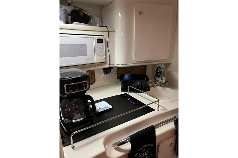 Slide: The Image of 1997 Sea Ray 290 Sundancer galley with microwave, coffee maker, and sink. - 19