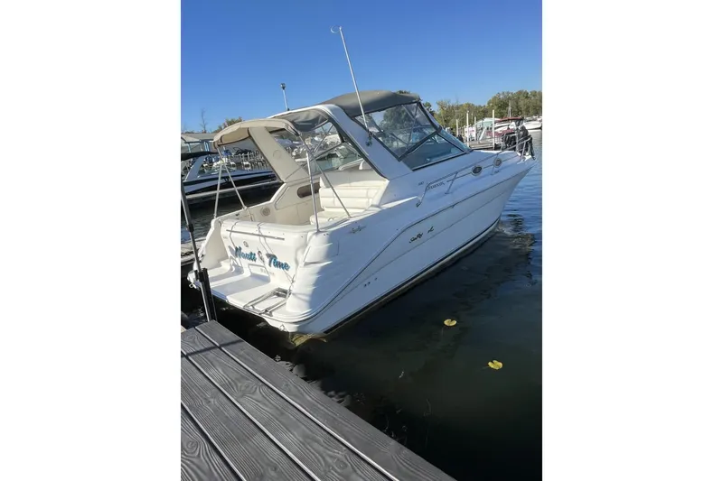 Slide: The Image of 1997 Sea Ray 290 Sundancer boat docked at marina under clear blue sky. - 2