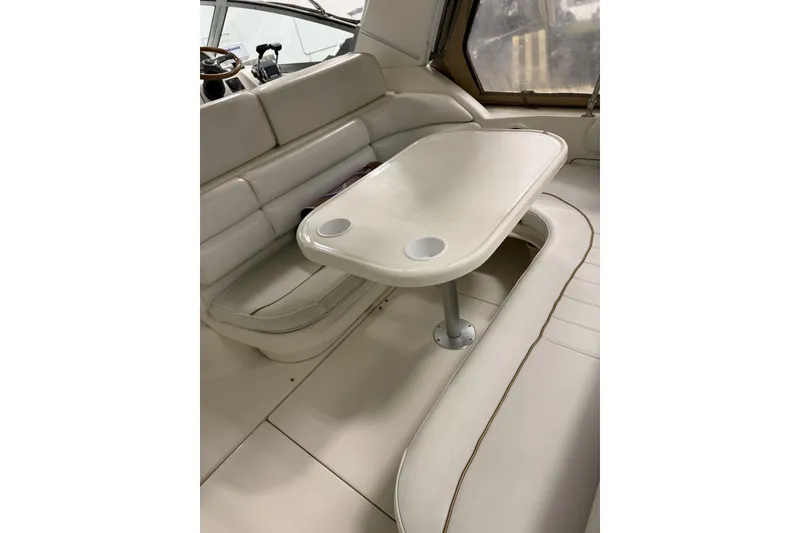 Slide: The Image of Interior of a 1997 Sea Ray 290 Sundancer boat with beige seating and table. - 6