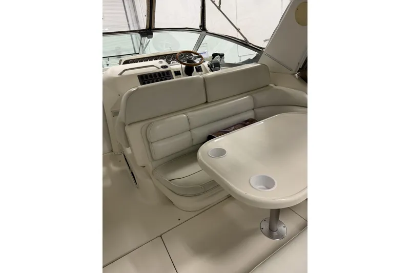 Slide: The Image of 1997 Sea Ray 290 Sundancer interior with helm, seating, and table. - 7