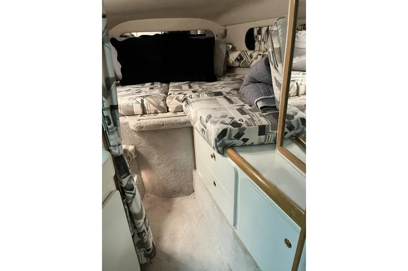 Slide: The Image of Interior cabin of 1997 Sea Ray 290 Sundancer with patterned bedding and storage cabinets. - 9