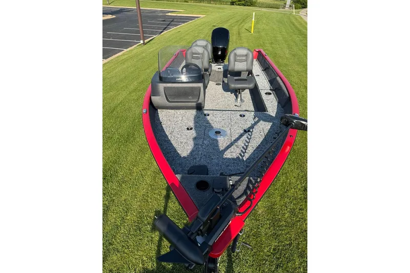 Slide: The Image of 2026 Tracker Pro Guide V-16 SC fishing boat on grass, featuring red exterior and seating. - 52