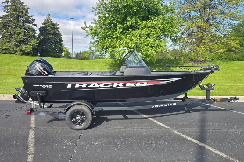 The Image of 2026 Tracker Pro Guide V-16 WT boat on trailer, parked outdoors. - 0