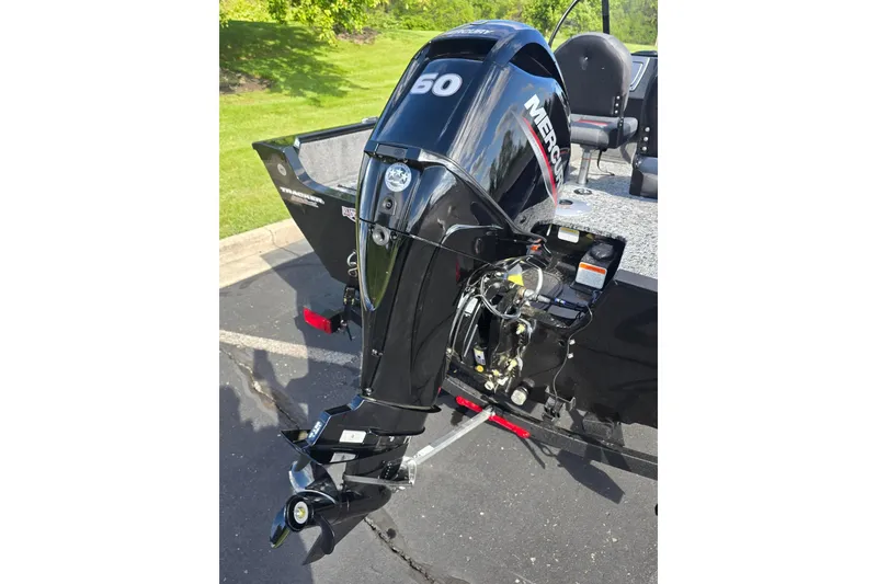 Slide: The Image of 2026 Tracker Pro Guide V-16 WT boat with Mercury 60 outboard motor in a parking lot. - 4