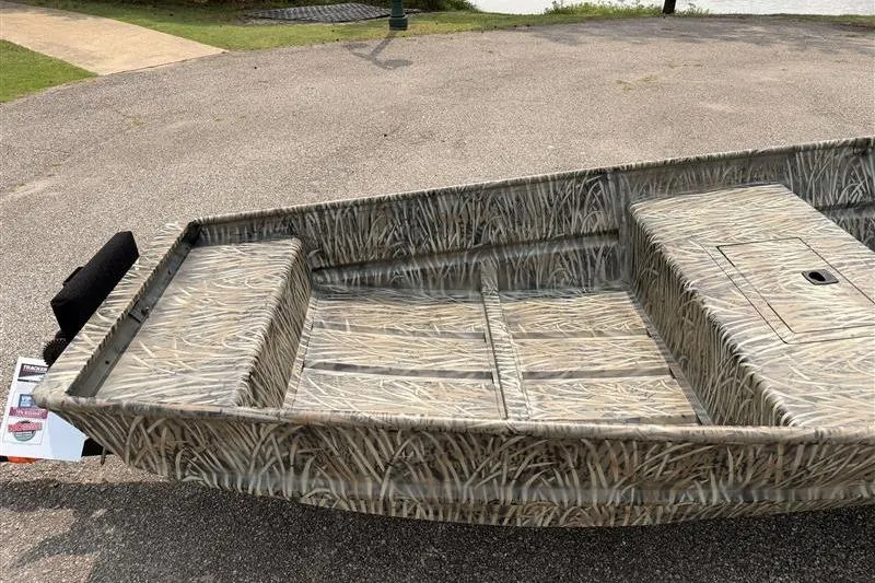 Slide: The Image of 2026 Tracker Grizzly 15 Jon boat with camouflage design on pavement. - 6