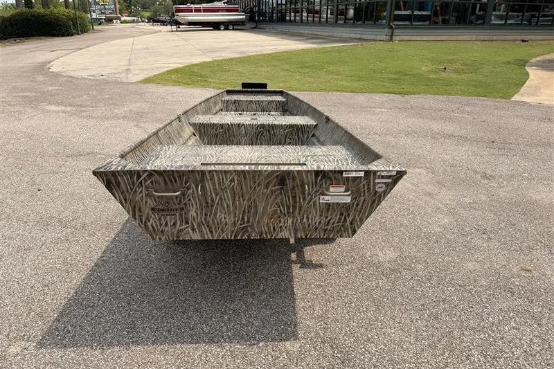 Slide: The Image of 2026 Tracker Grizzly 15 Jon boat with camouflage design on pavement. - 3