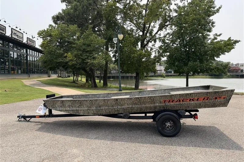 The Image of 2026 Tracker Grizzly 15 Jon boat on trailer, parked near a scenic lake. - 0