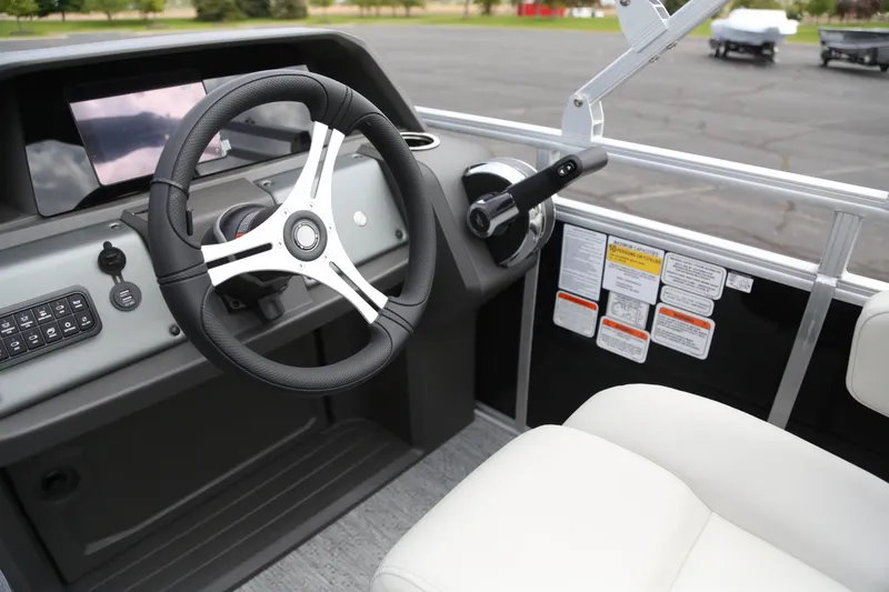 Slide: The Image of 2026 Sun Tracker Fishin' Barge 20 DLX steering console with modern controls and comfortable seating. - 5