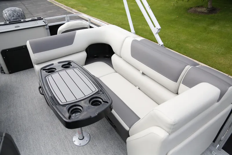 Slide: The Image of 2026 Sun Tracker Fishin' Barge 20 DLX interior with cushioned seating and table. - 6