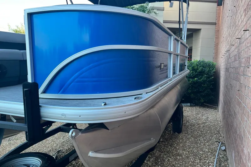 Slide: The Image of 2026 Sun Tracker Party Barge 18 DLX pontoon boat with blue exterior, parked outdoors. - 2
