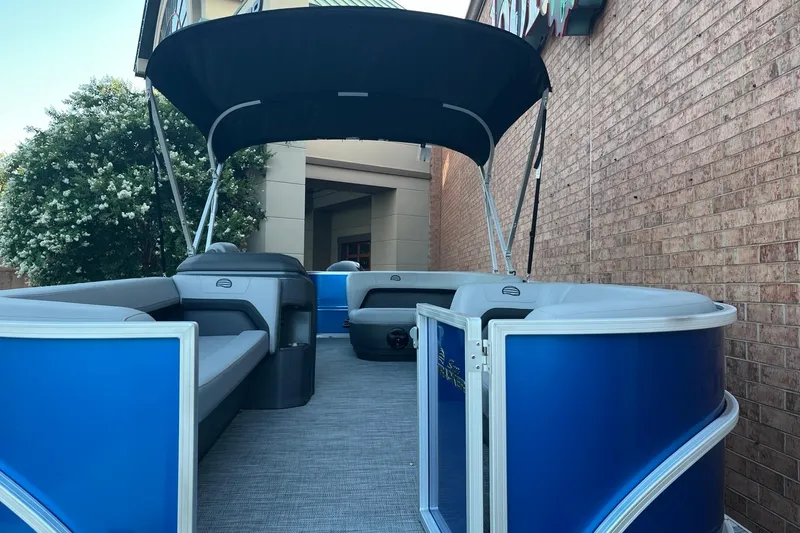 Slide: The Image of 2026 Sun Tracker Party Barge 18 DLX pontoon boat with blue exterior and canopy. - 4