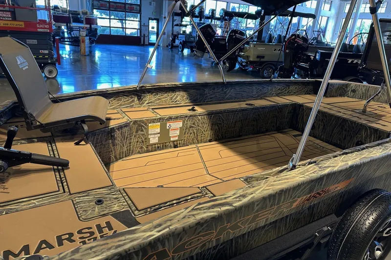 Slide: The Image of 2026 Tracker Grizzly 1756 T Marsh boat interior with camouflage design in showroom. - 4