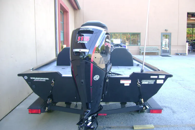 Slide: The Image of 2026 Tracker Pro Team 190 boat with Mercury 115 Pro XS engine, parked outside a building. - 4