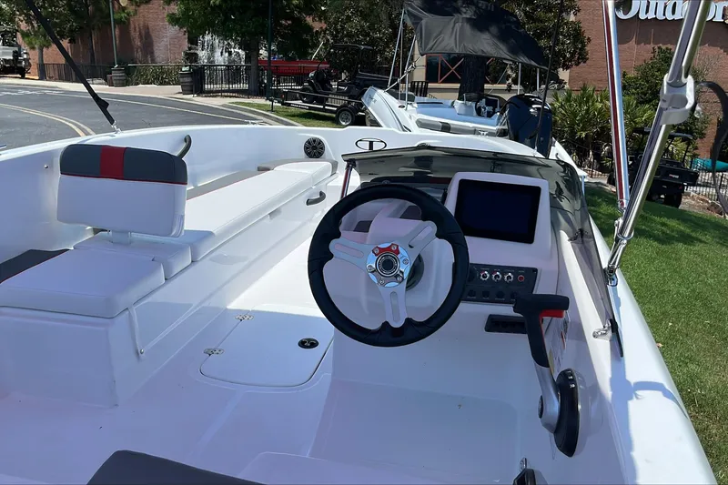 Slide: The Image of 2026 Tahoe T18 boat interior with steering wheel and seating, displayed outdoors. - 6