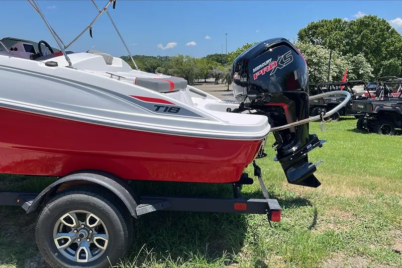 Slide: The Image of 2026 Tahoe T18 boat with Mercury Pro XS engine on a trailer, parked on grass. - 3