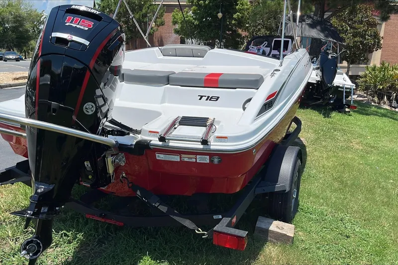 Slide: The Image of 2026 Tahoe T18 boat with Mercury 115 engine on a trailer, parked on grass. - 5